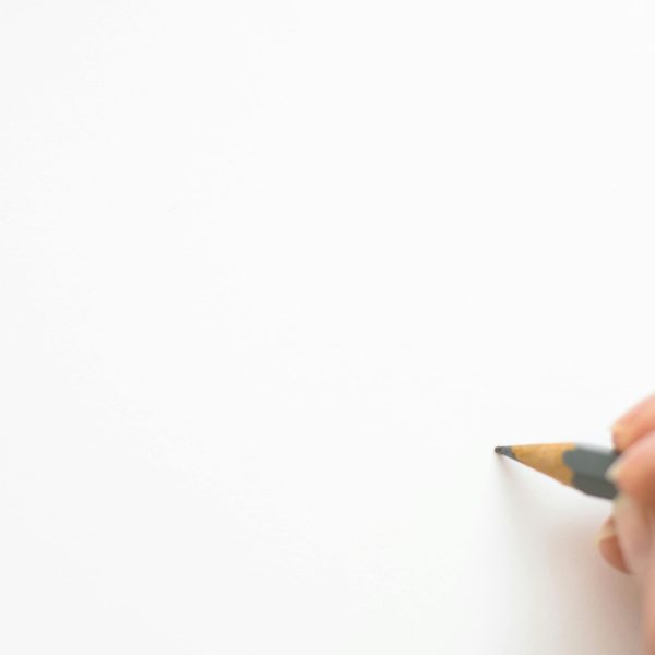 pexels-photo-316466-316466 Close-up of a hand sketching on white paper with a pencil, emphasizing creativity.